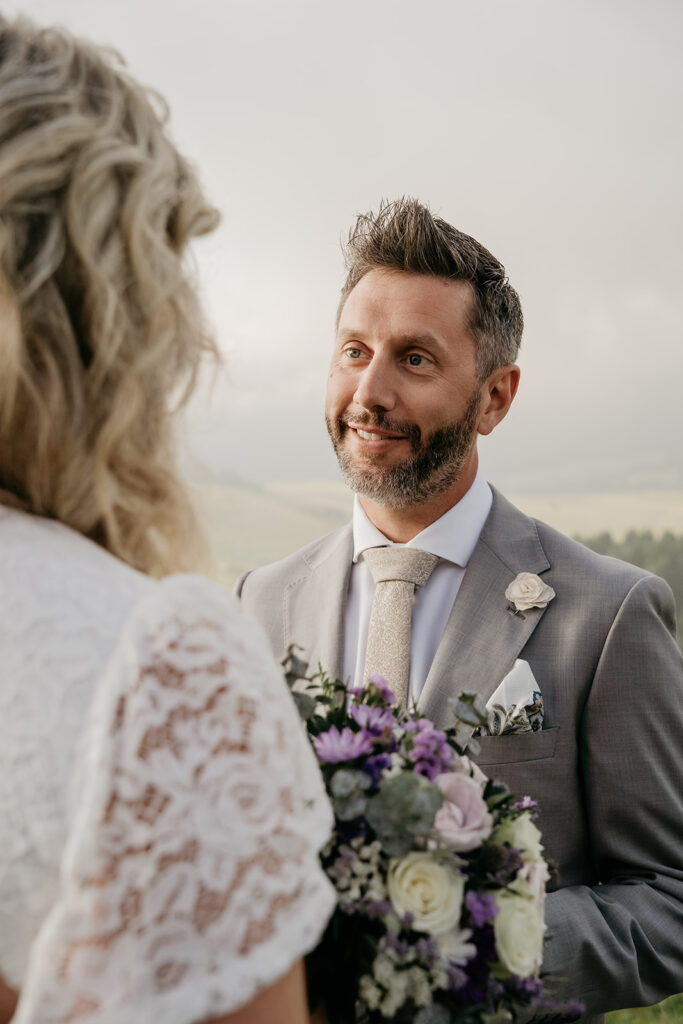 Bride and groom exchanging vows outdoors.