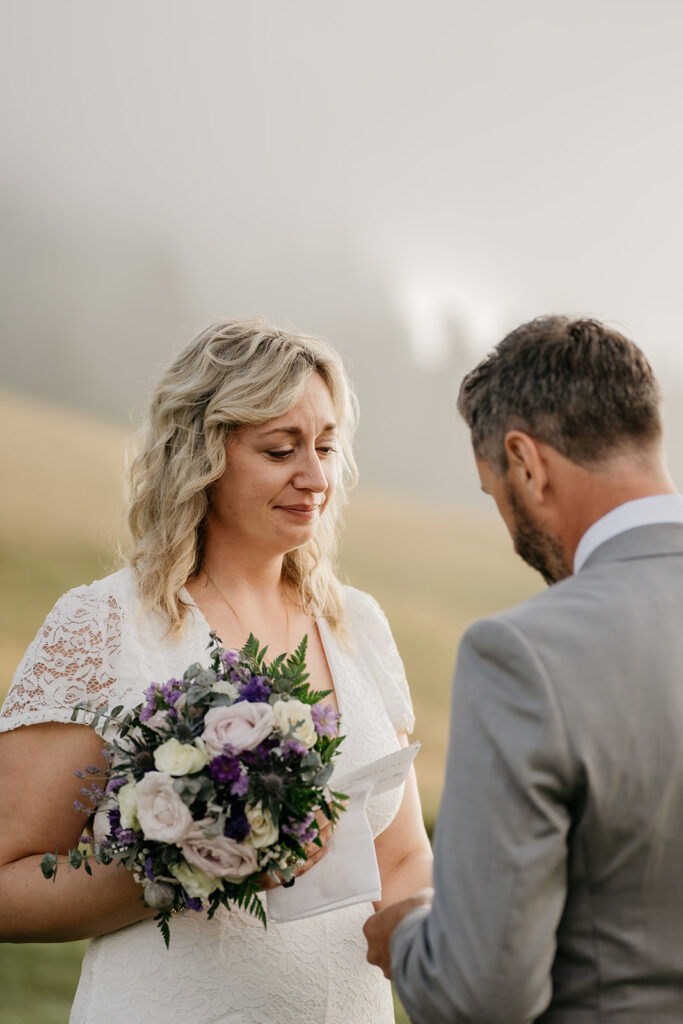 Wedding ceremony with bride and groom holding flowers.