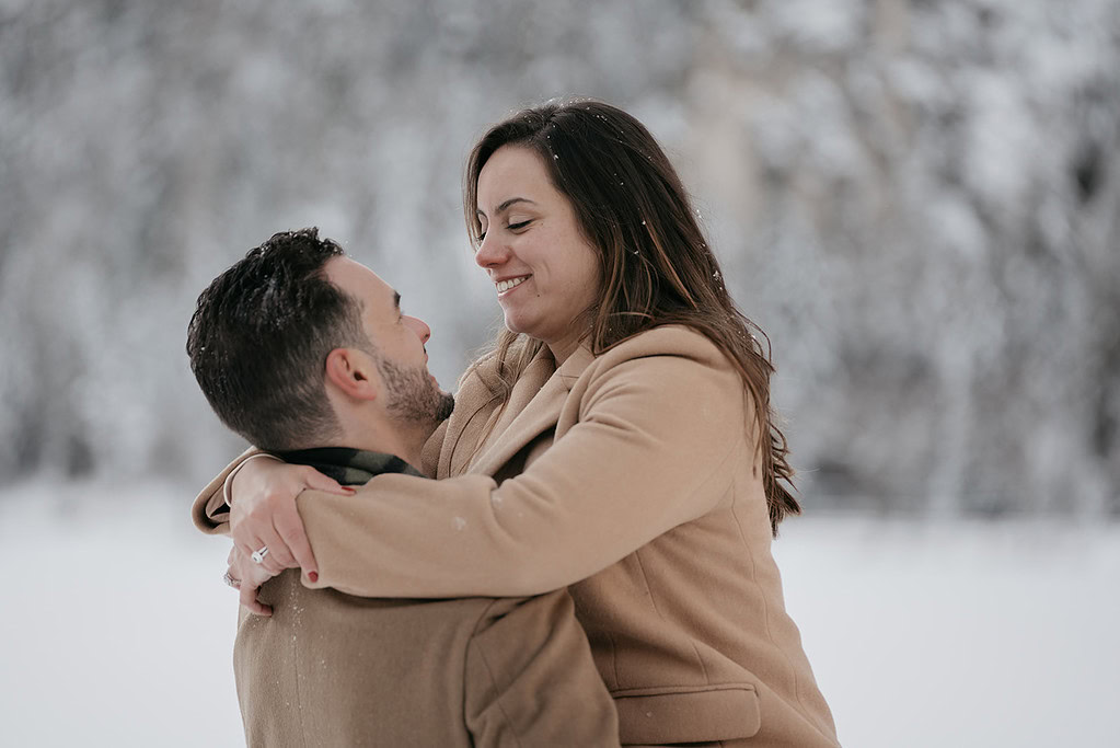 Smiling couple embracing in snowy landscape