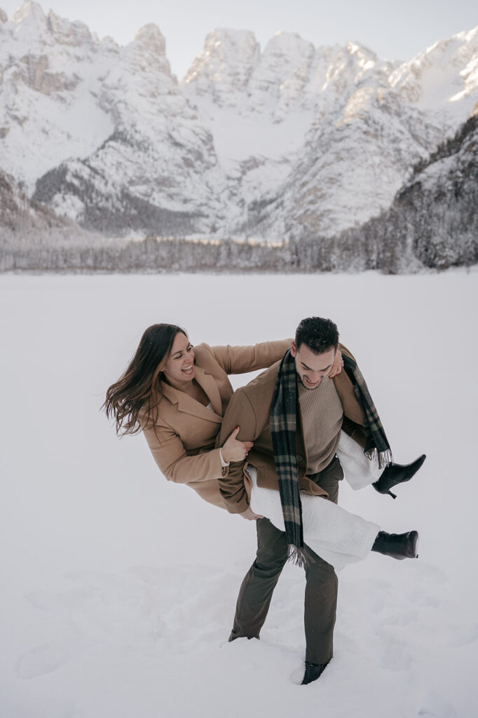 Couple playing in snowy mountain landscape