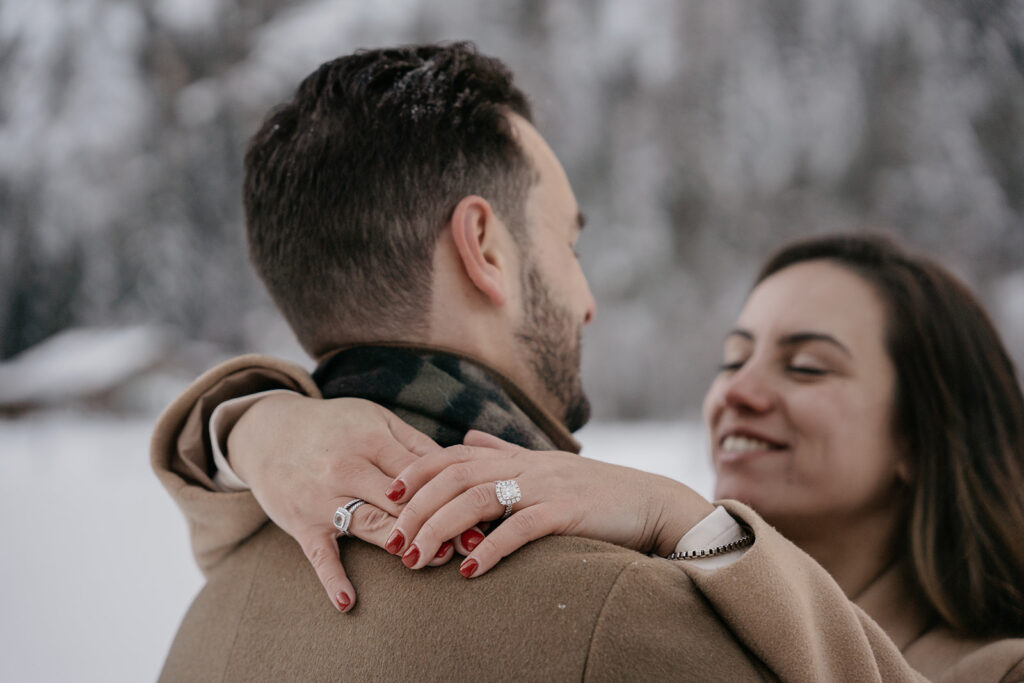 Couple embracing in snowy outdoor setting.