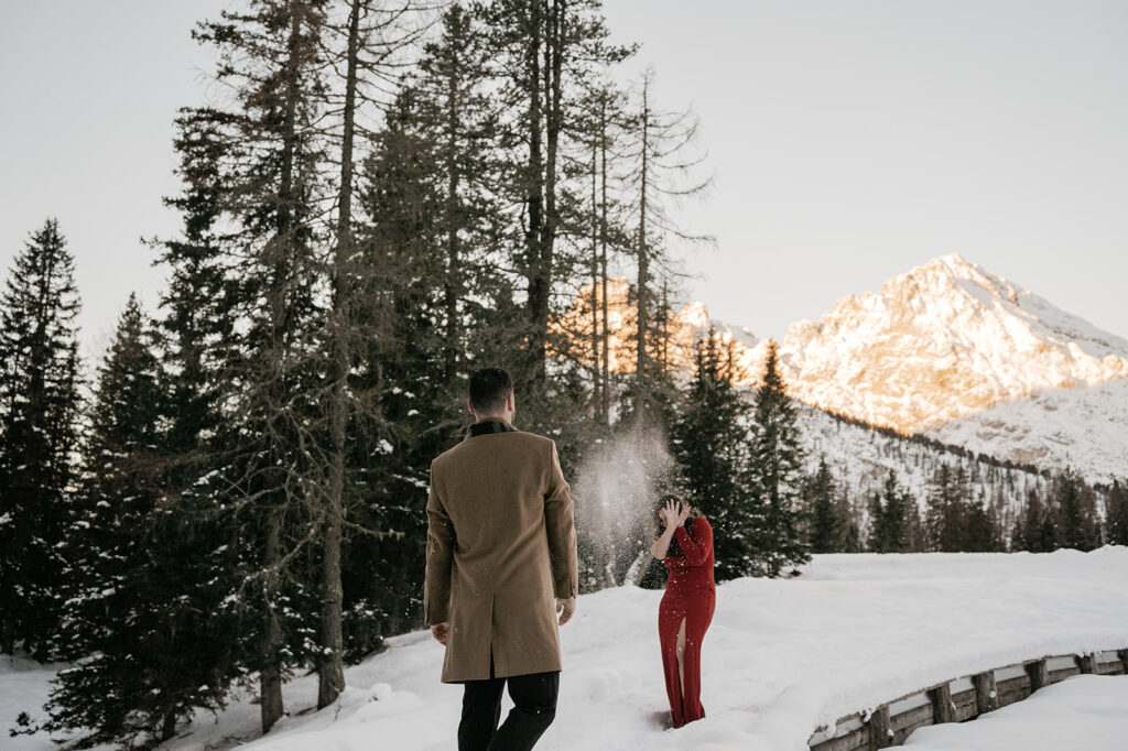 Snowball play in snowy forest with mountain view.