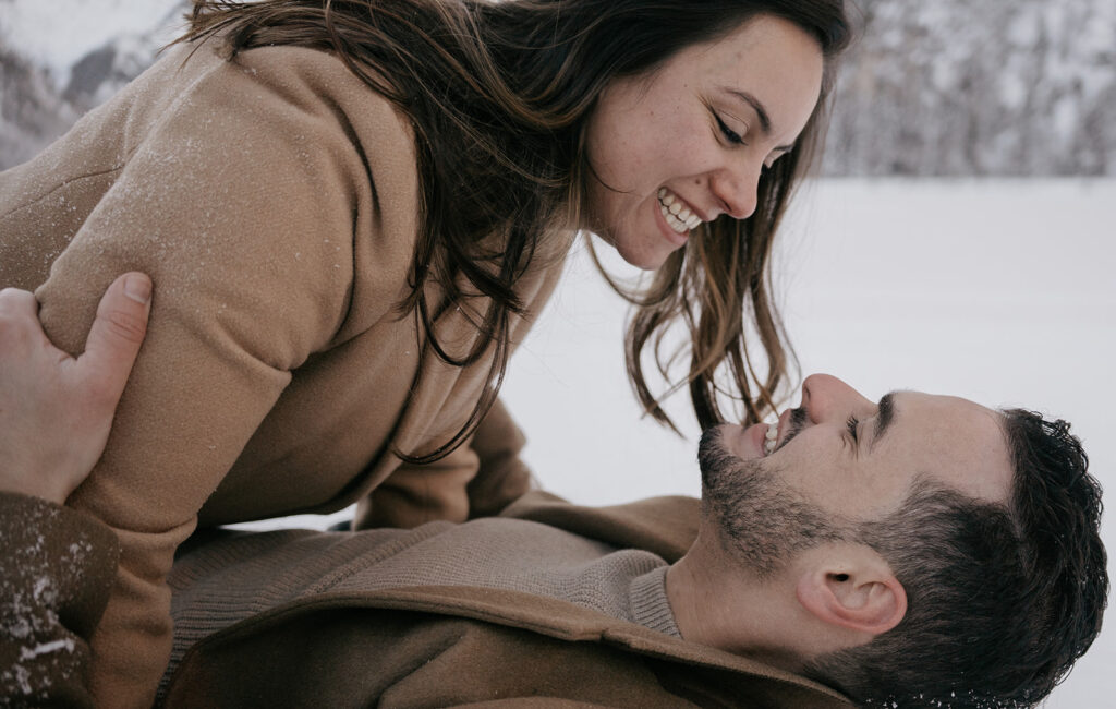 Smiling couple enjoying playful moment in snow