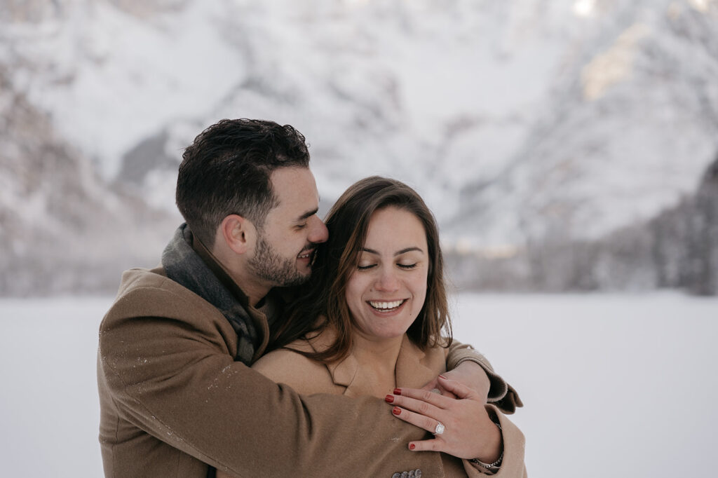 Couple embracing happily in snowy landscape.