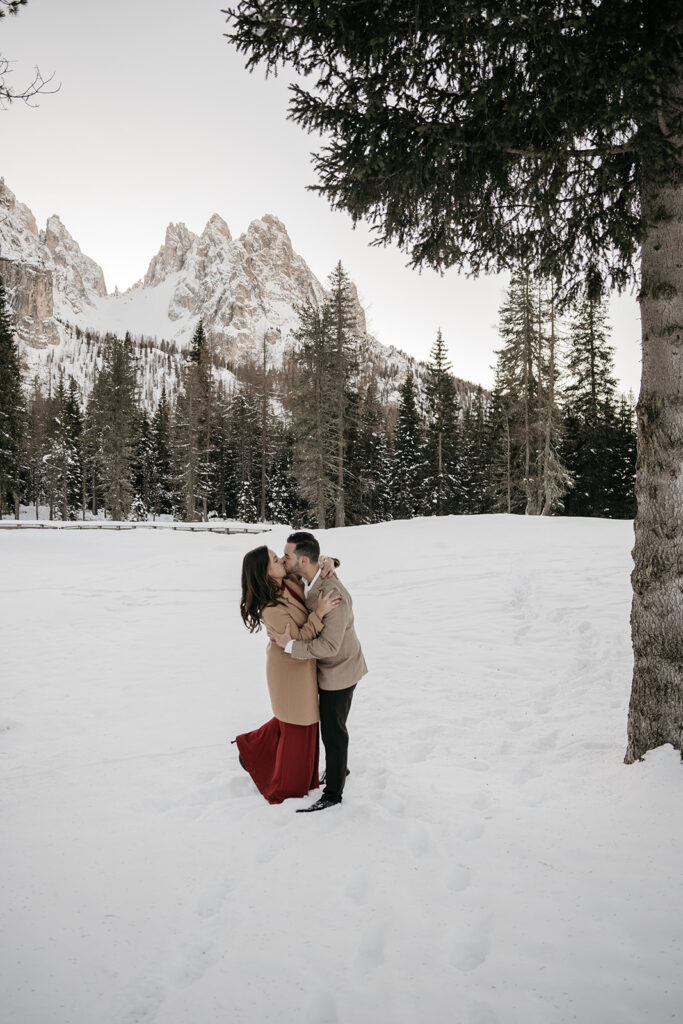 Couple kissing in snowy mountain landscape