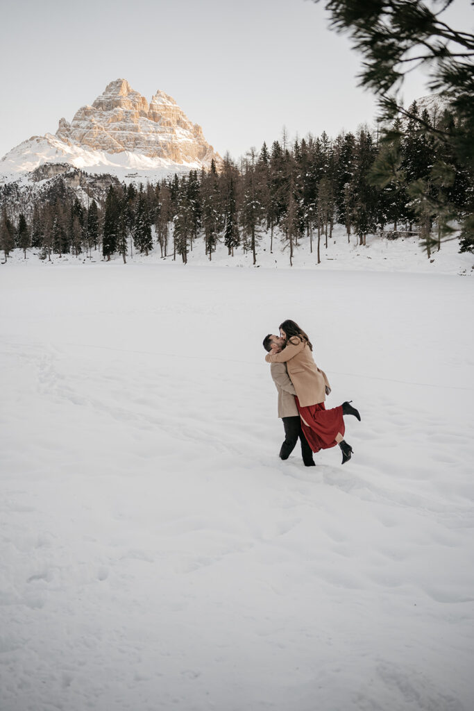 Couple embracing in snowy mountain landscape