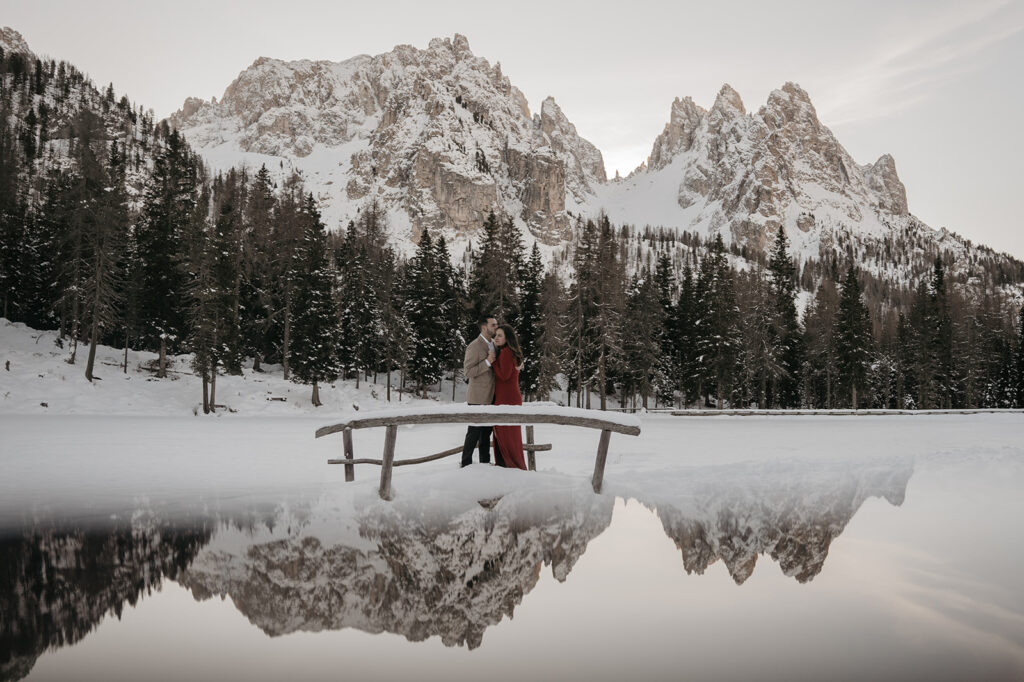 Couple embracing on snowy mountain landscape.