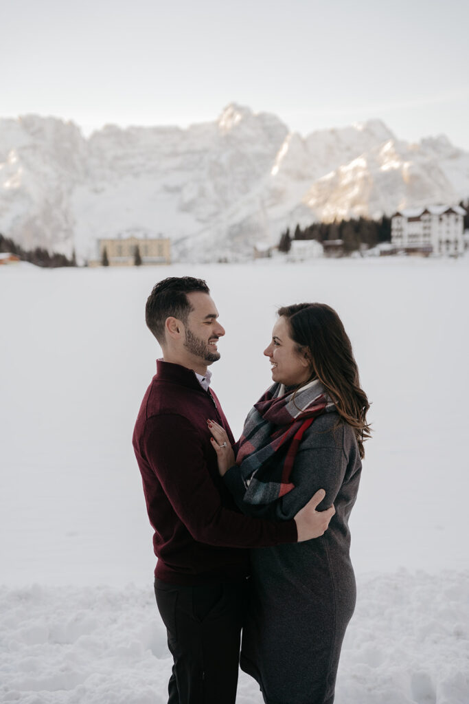 Couple embraces in snowy mountain landscape