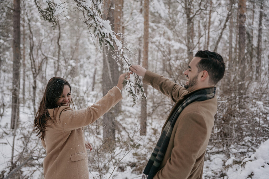 Couple playing in snowy forest