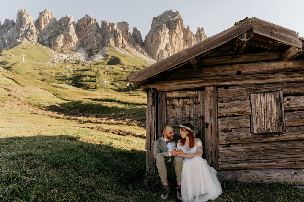 Couple sitting by rustic cabin in the mountains.