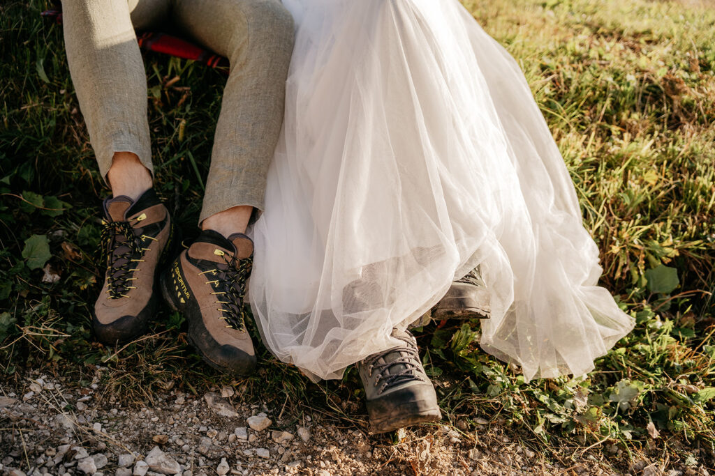 Bride and groom wearing hiking boots outdoors.