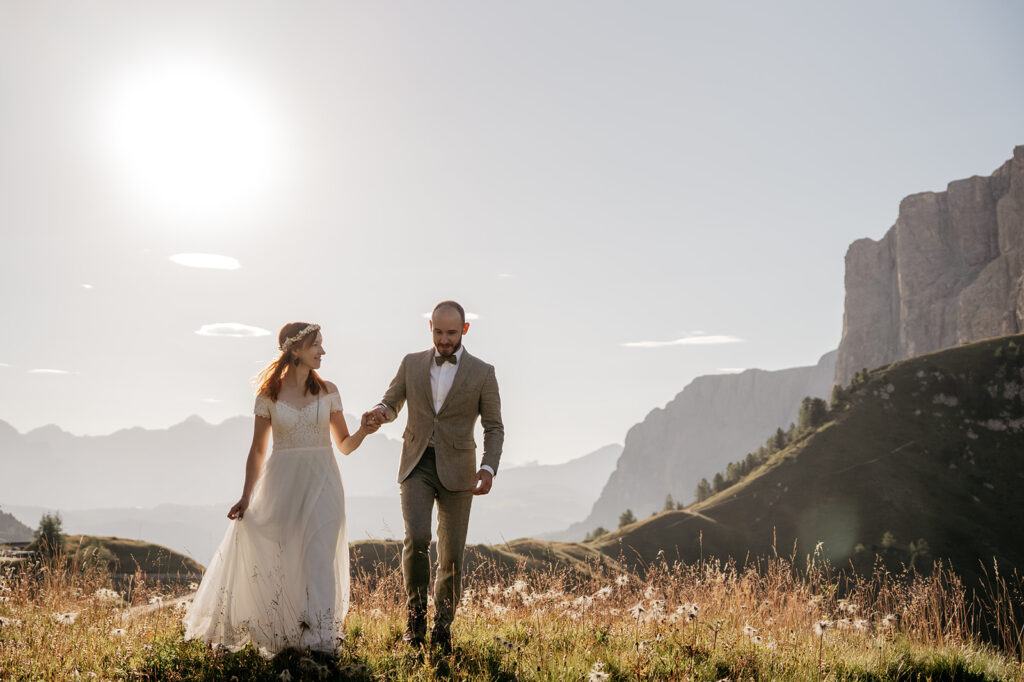 Couple walking in mountain landscape at sunset.