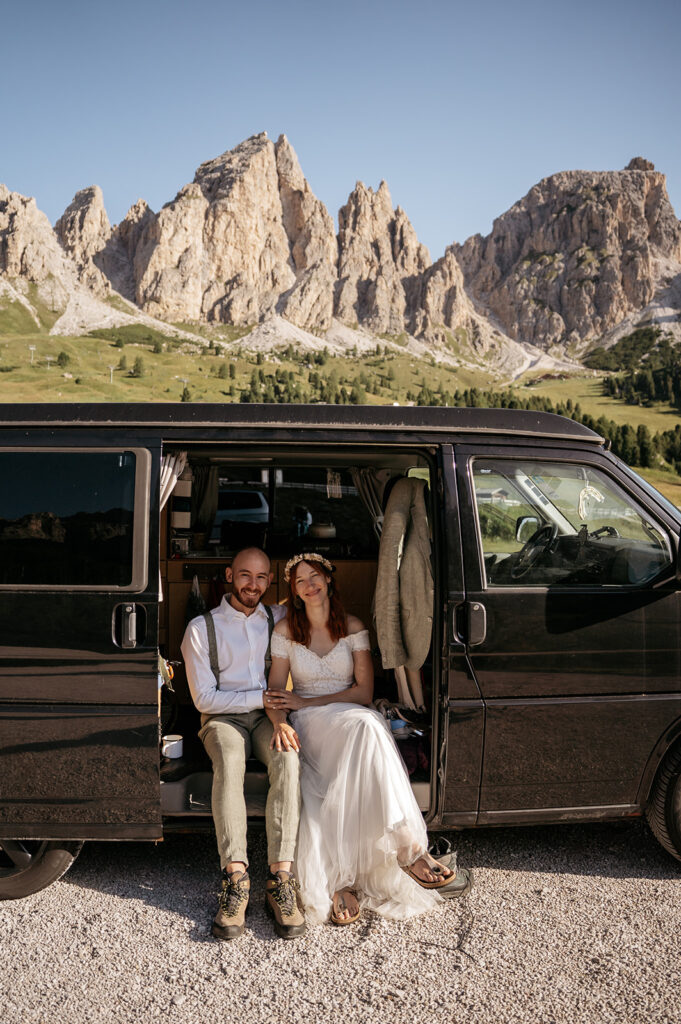 Couple seated in van, mountain backdrop