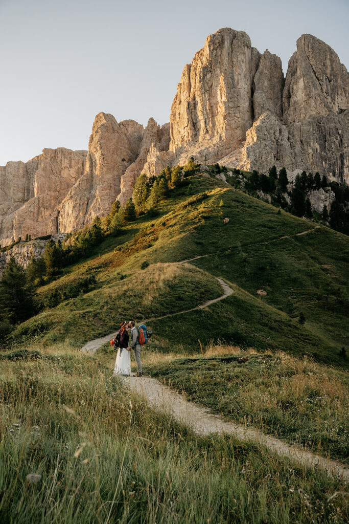 Couple hiking on mountain path at sunset