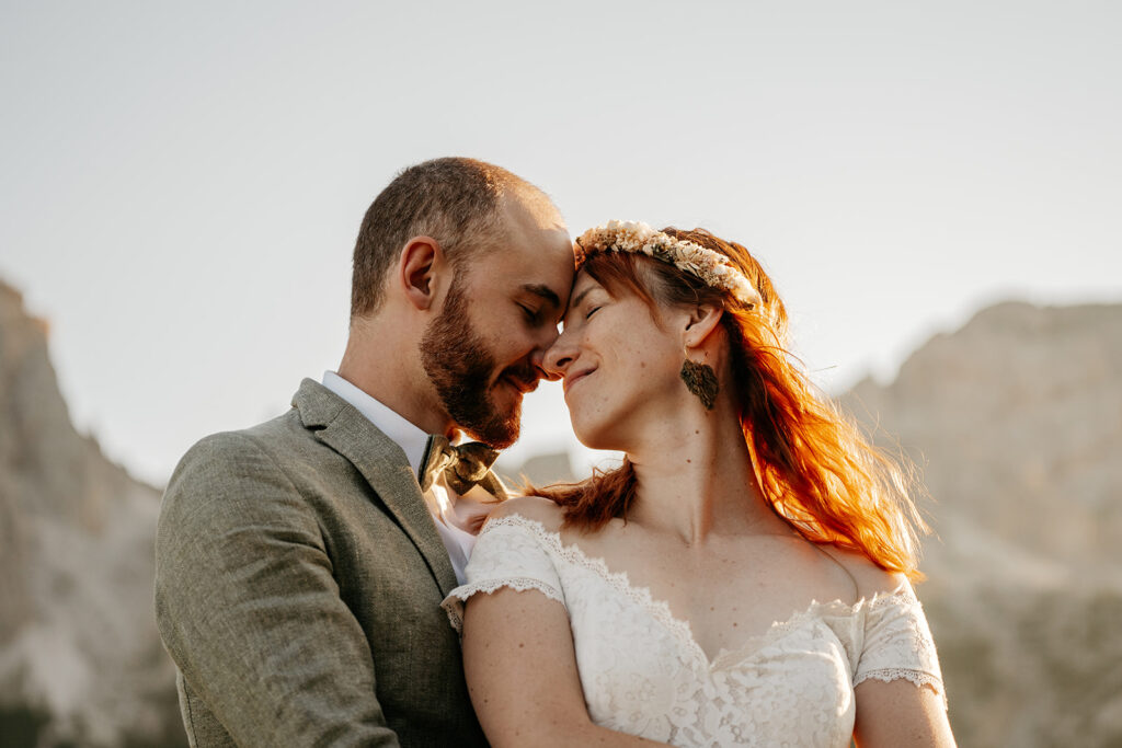 Bride and groom embracing in nature setting.