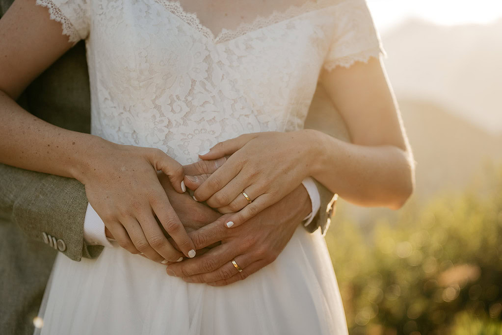 Couple embracing at wedding in sunlight.