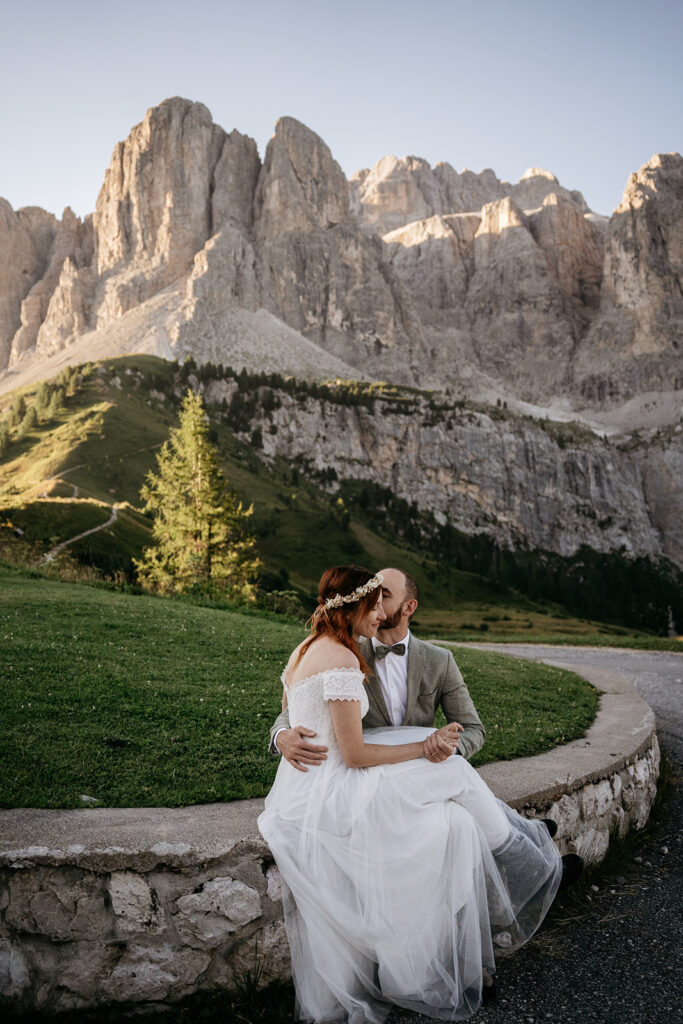 Couple embraces with mountain backdrop at wedding.