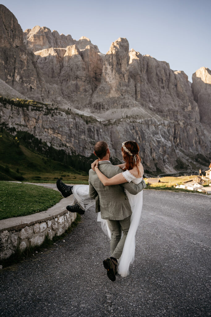 Bride and groom embrace in mountain setting.