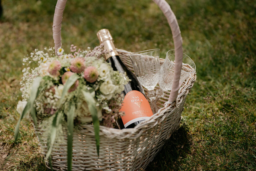 Picnic basket with wine, glasses, and flowers