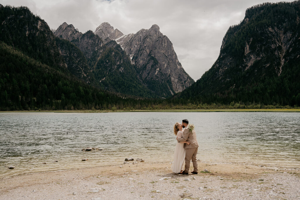 Couple kissing by a mountain lake