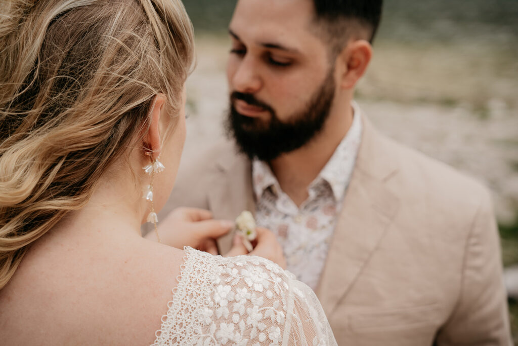 Couple preparing for wedding ceremony outdoors.