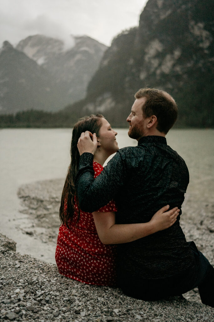 Couple embracing by a lake and mountains