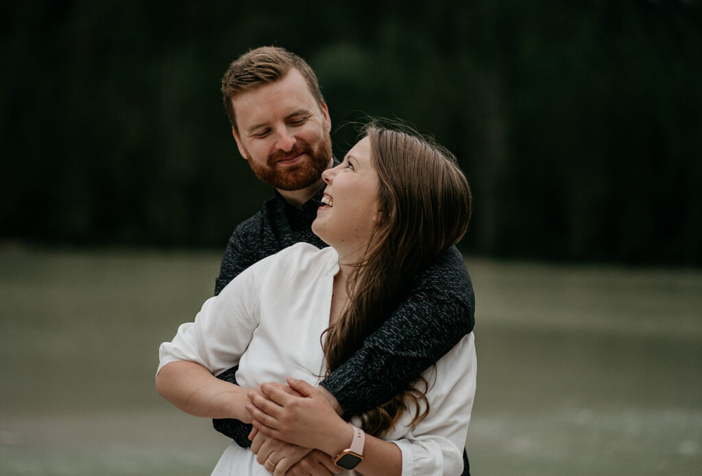 Couple embracing outdoors, smiling lovingly.