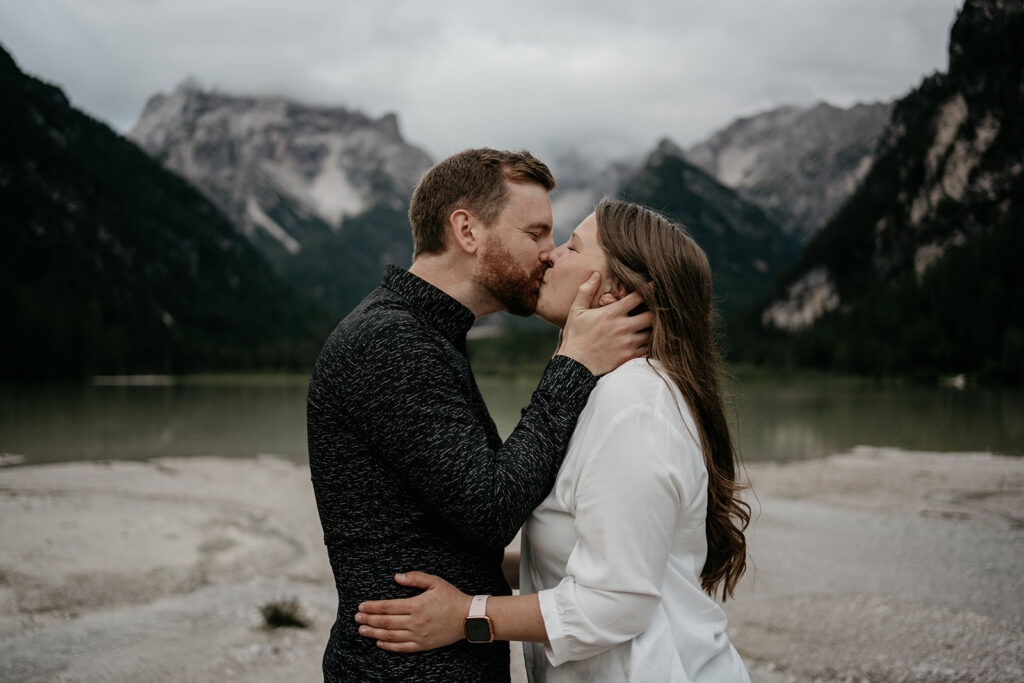 Couple kissing by mountain lake view