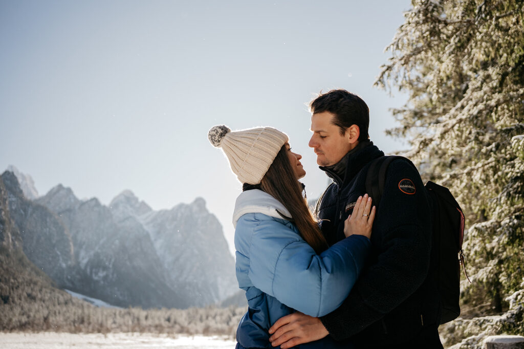 Couple embraces in snowy mountain landscape