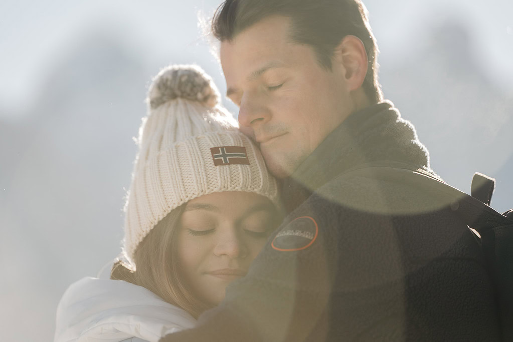 Couple embracing outdoors in winter clothing.