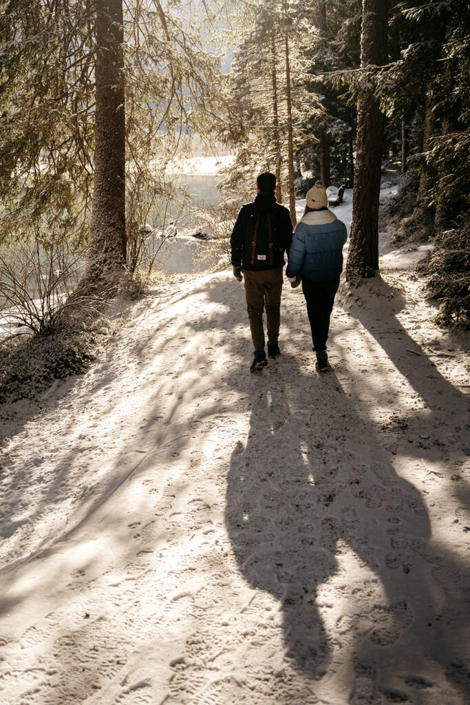 Couple walking on snowy forest trail