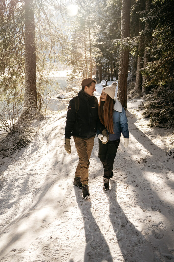 Couple walking in snowy forest path