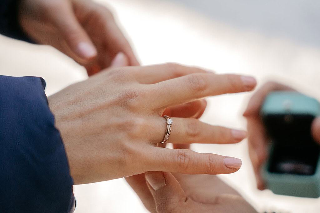 Engagement ring being placed on woman's finger