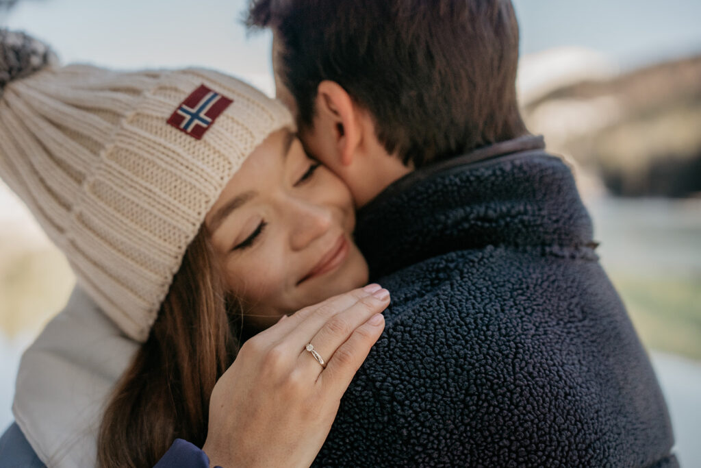 Couple hugging outdoors, woman wearing knit hat.