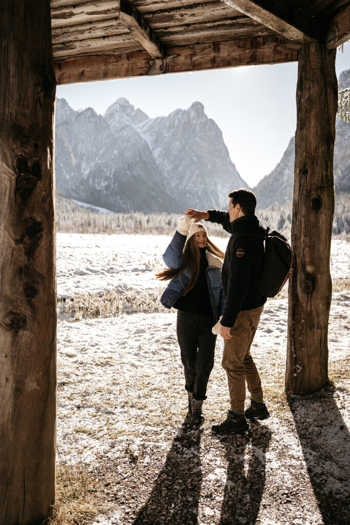 Couple dancing under snowy mountain scenery.