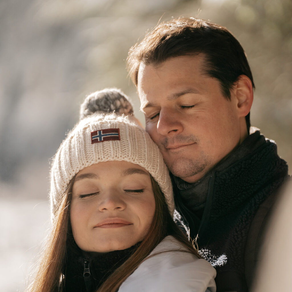 Couple embracing outdoors in winter attire.