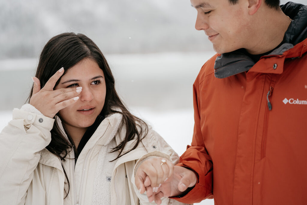 Emotional moment during outdoor proposal in winter snow.