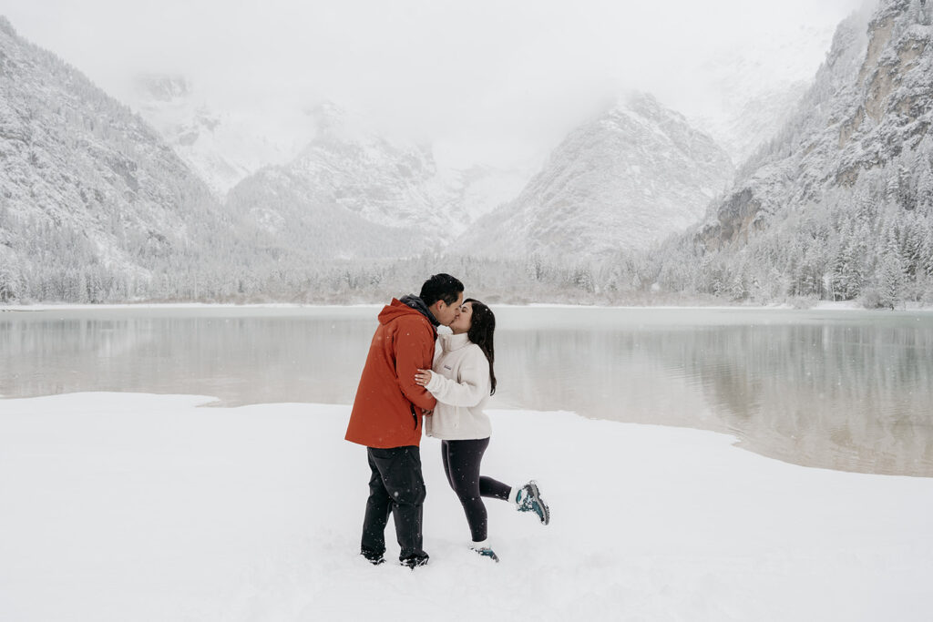 Couple kissing in snowy mountain landscape