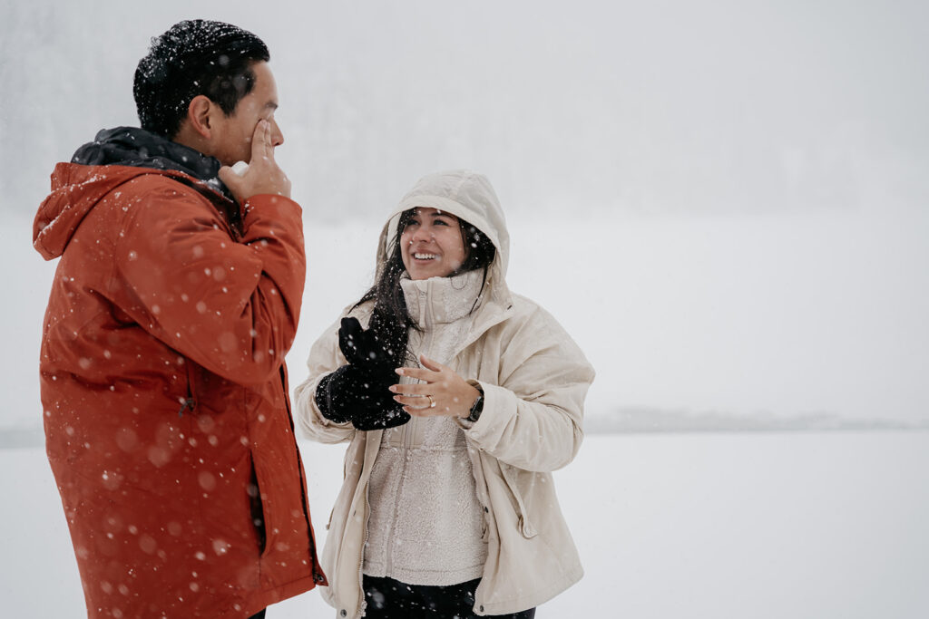 Couple talking in snowy outdoor setting.