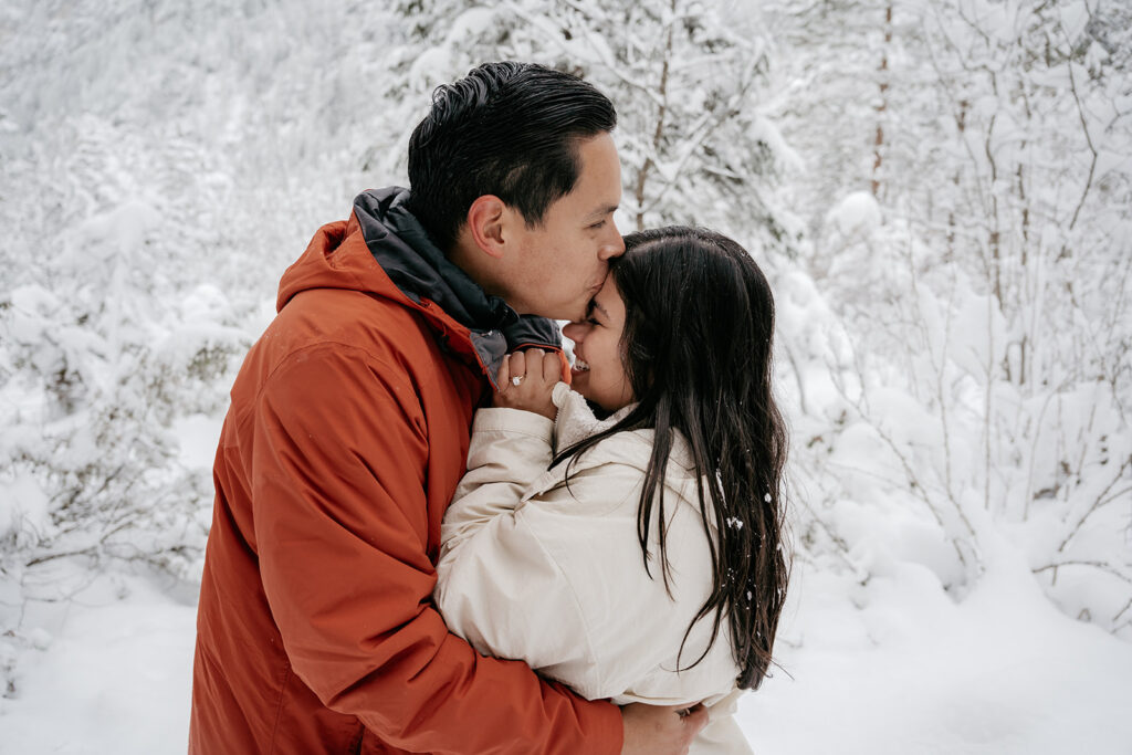 Couple embraces in snowy forest scene