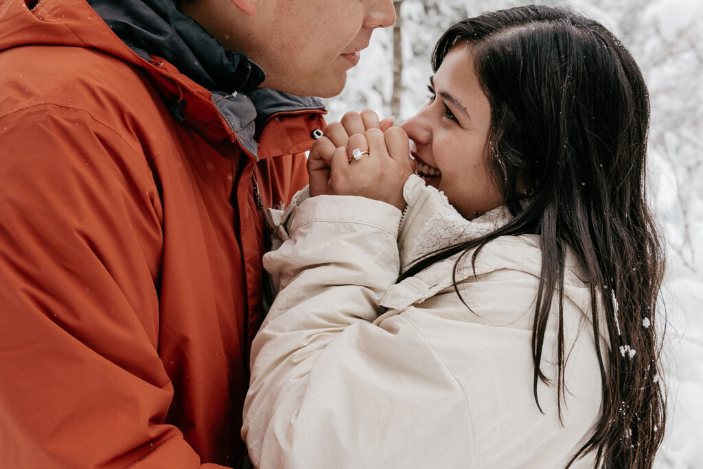 Couple smiling in snowy winter landscape