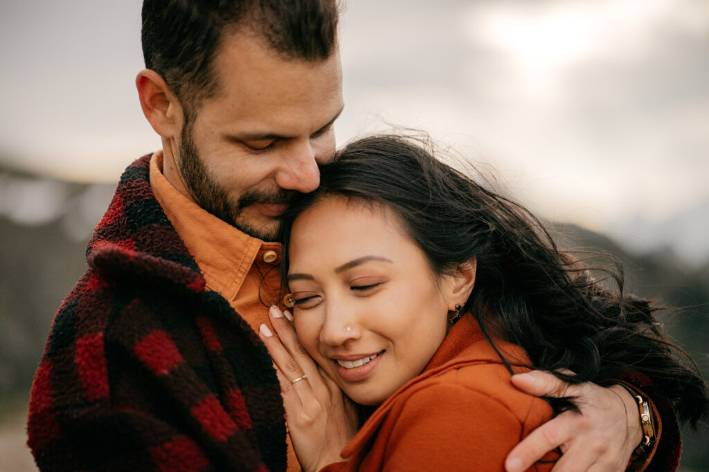 Couple embracing outdoors with closed eyes.