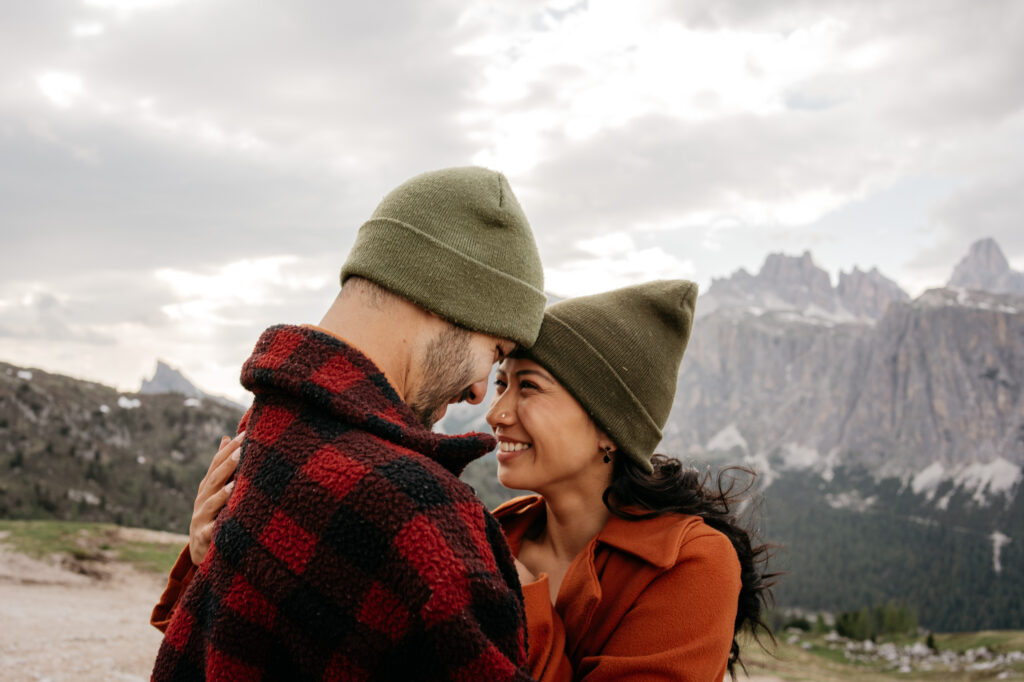 Smiling couple embracing in mountain landscape.