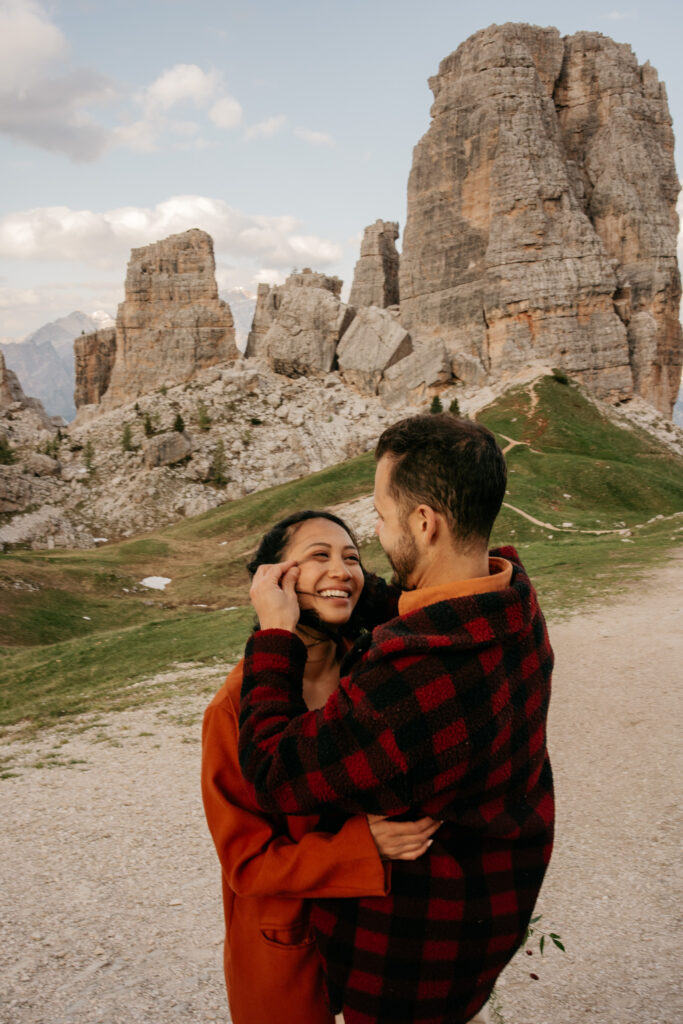 Couple embracing near mountain landscape.