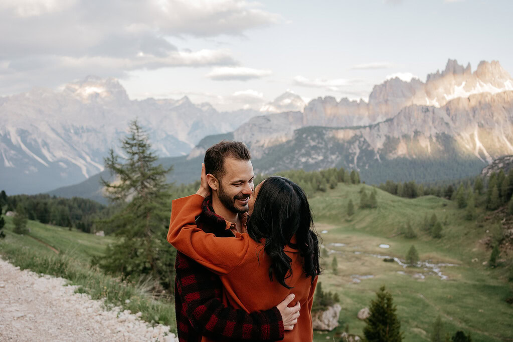 Couple embracing in scenic mountain landscape.