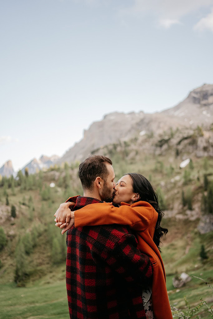 Couple kissing in mountain landscape.