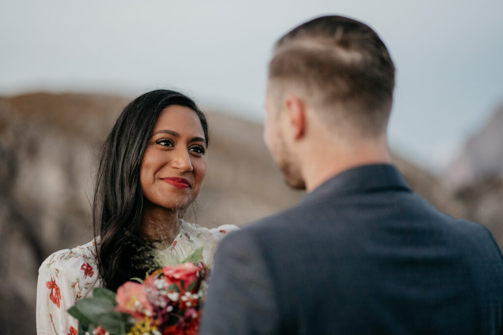 Couple exchanging smiles with flowers in hand