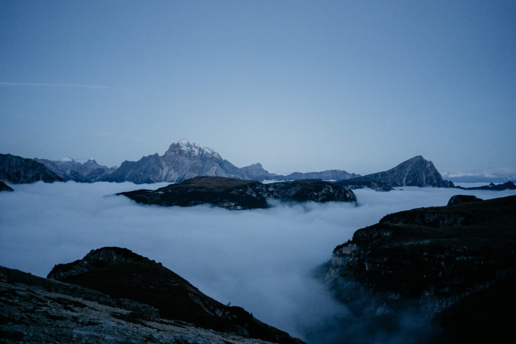 Foggy mountains during twilight with cloudy sky.