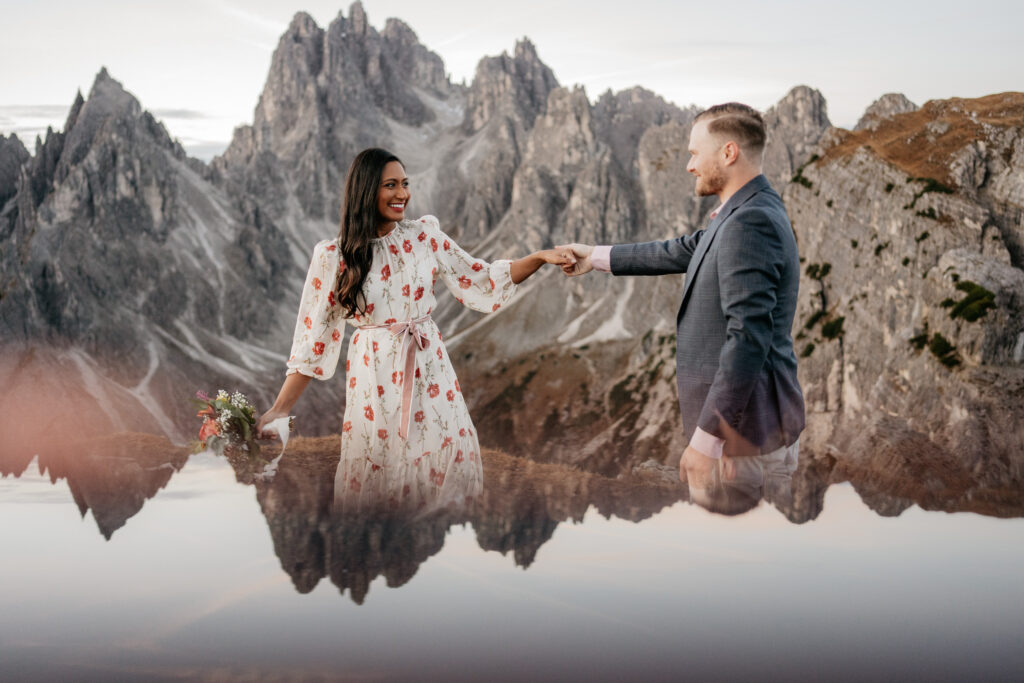 Couple dances in mountain landscape with reflection view.