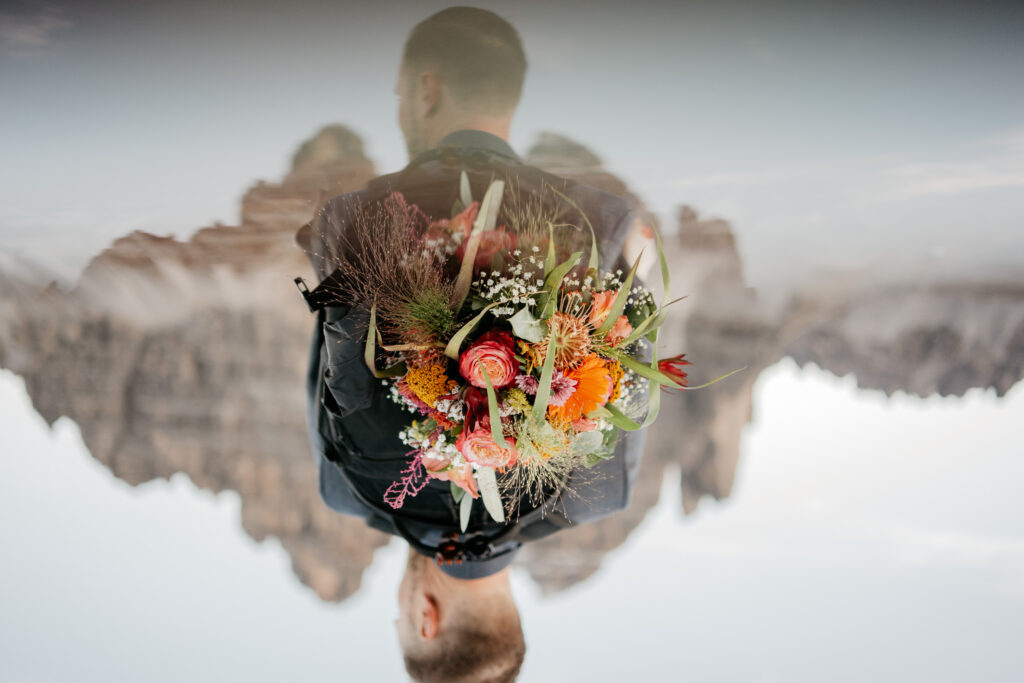 Person carrying colorful flower bouquet outdoors.